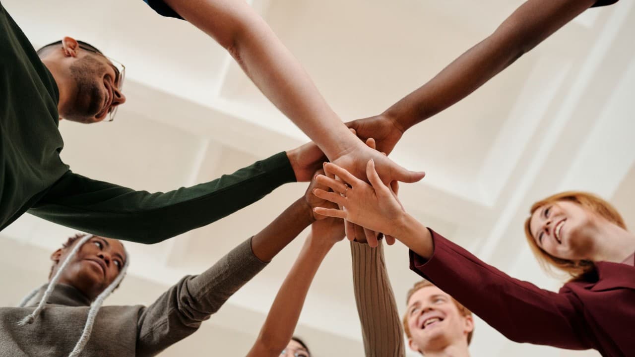 Diverse team joining hands together